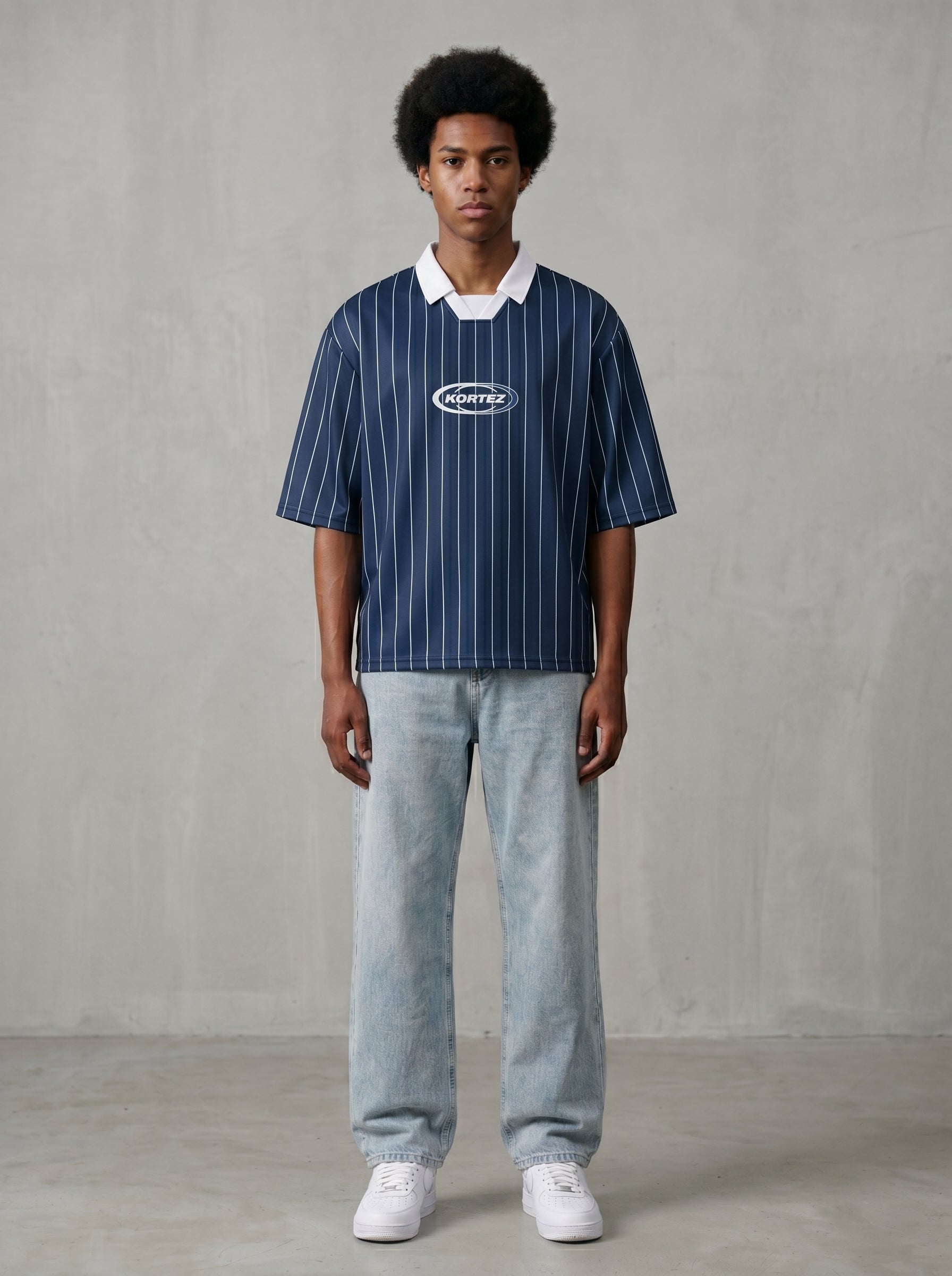 Navy blue pinstripe collared soccer jersey worn by man with afro